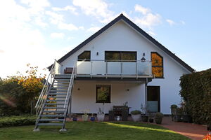 Gartenansicht seriell saniertes Haus mit Balkon
